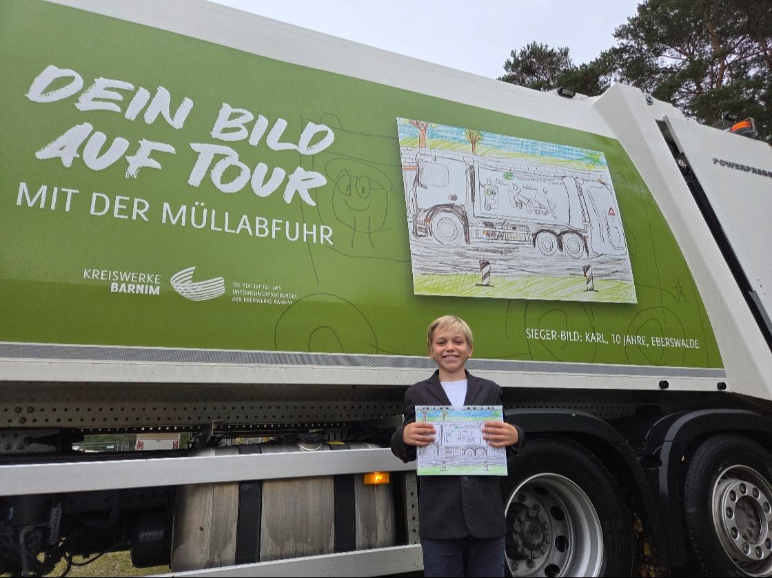 Der 10-jährige Karl Balzer aus Eberswalde präsentiert stolz sein Originalbild, welches auf dem Müllfahrzeug verewigt wurde. Foto: Kreiswerke Barnim