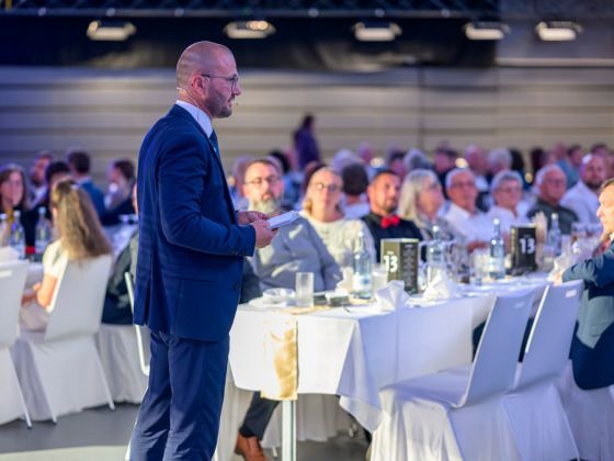 Mit rund 400 Gäst*innen feiert der Unternehmensverbund der Kreiswerke sein 10-jähriges Bestehen. Christian Mehnert geht während seiner Rede durch die Reihen. (Foto: Thomas Matena / Matena Moments)
