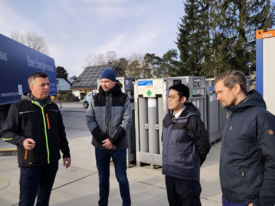 (Foto: Kreiswerke Barnim) Besichtigung Wasserstofftankstelle (v.l.n.r.: Christian Heise (Projektleiter Wasserstoffinfrastruktur, Kreiswerke Barnim GmbH), Mathias Böhm (Projektleiter H2BAR Begleitforschung Fahrzeuge und Tankstelle, Deutsches Zentrum für Luft- und Raumfahrt), Shun Iwatsuki (East Japan Railway Company) und Benjamin Voigt (Senior Referent grüne Bahntechnik, Deutsche Bahn)) 